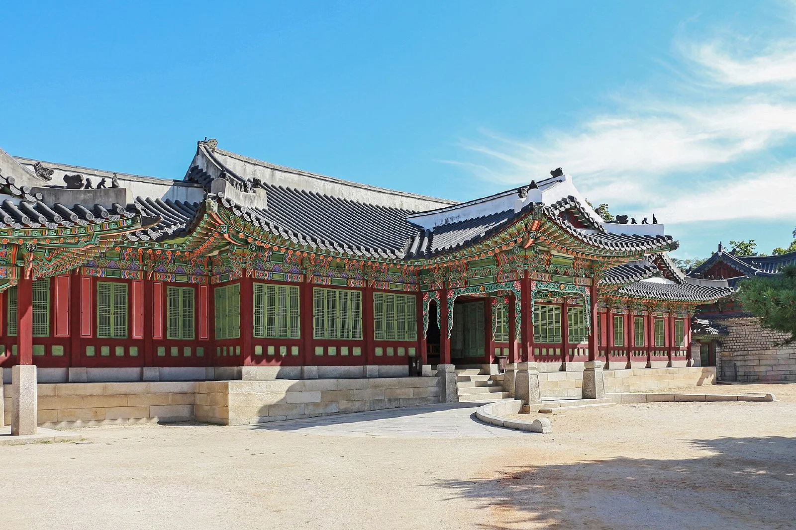 기와지붕 아래 붉은 기둥과 창호가 이어진 창덕궁 희정당 건물 외관